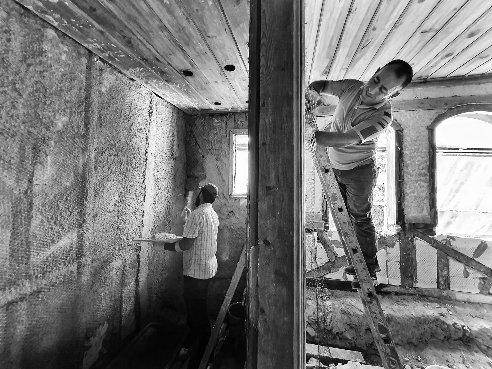 Artisans appliquant un enduit lors d'une rénovation intérieure