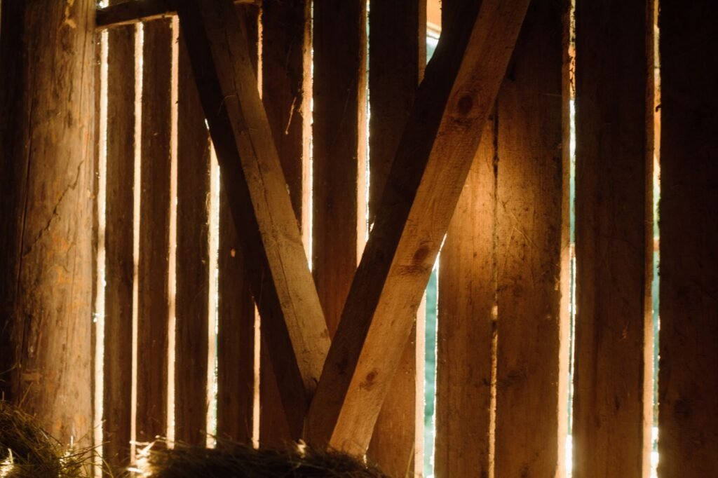 Lumière traversant la charpente en bois d'une ancienne grange