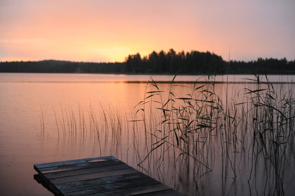 Ponton en bois sur un lac calme au coucher du soleil