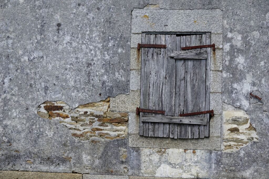 Fenêtre rustique en bois dans un mur en pierre de maison ancienne