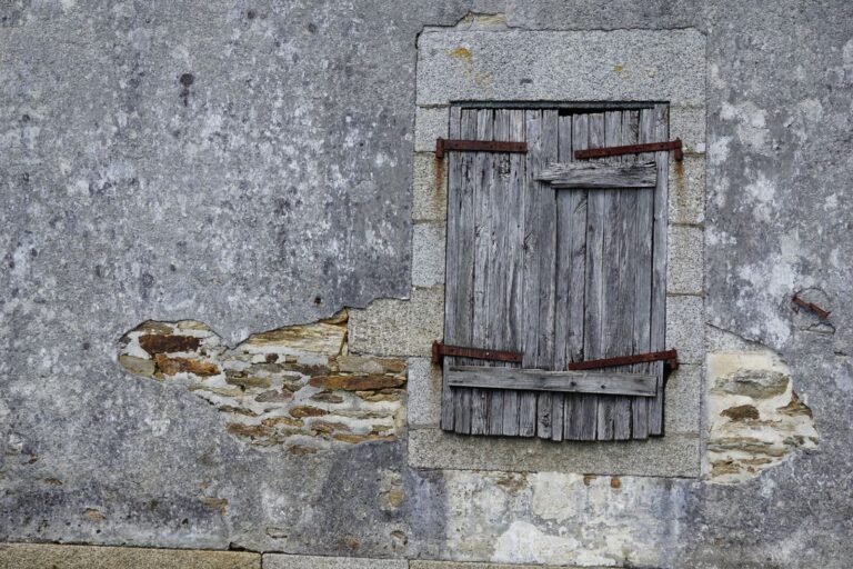 Fenêtre rustique en bois dans un mur en pierre de maison ancienne