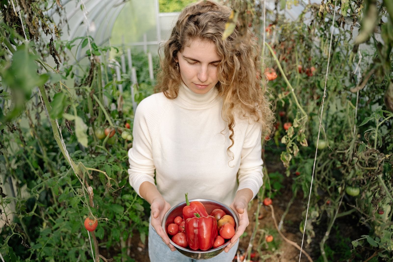 Femme portant des légumes fraîchement récoltés au potager